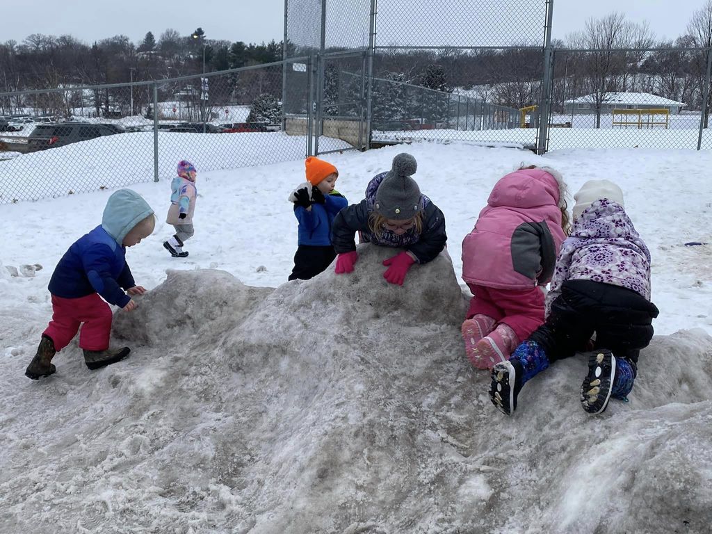 Children playing on a hill of snow